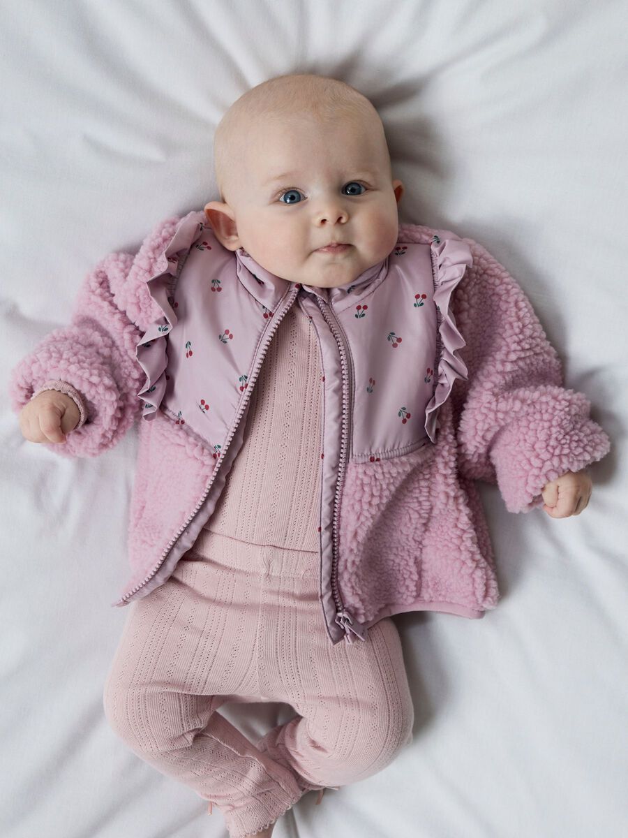 Baby in een roze NAME IT-sherpajasje