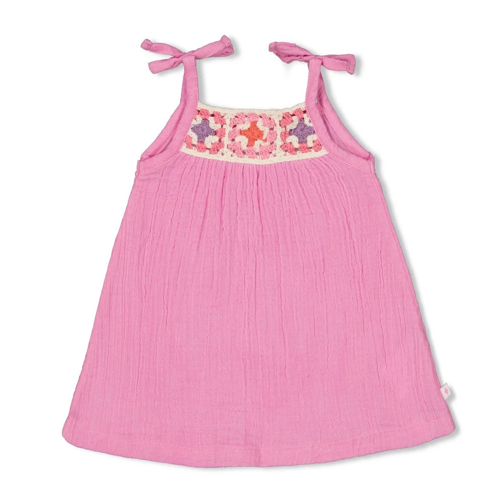 Officiële productfoto van een fuchsia Feetje-babyjurkje met strikbandjes en gehaakte bloemen.