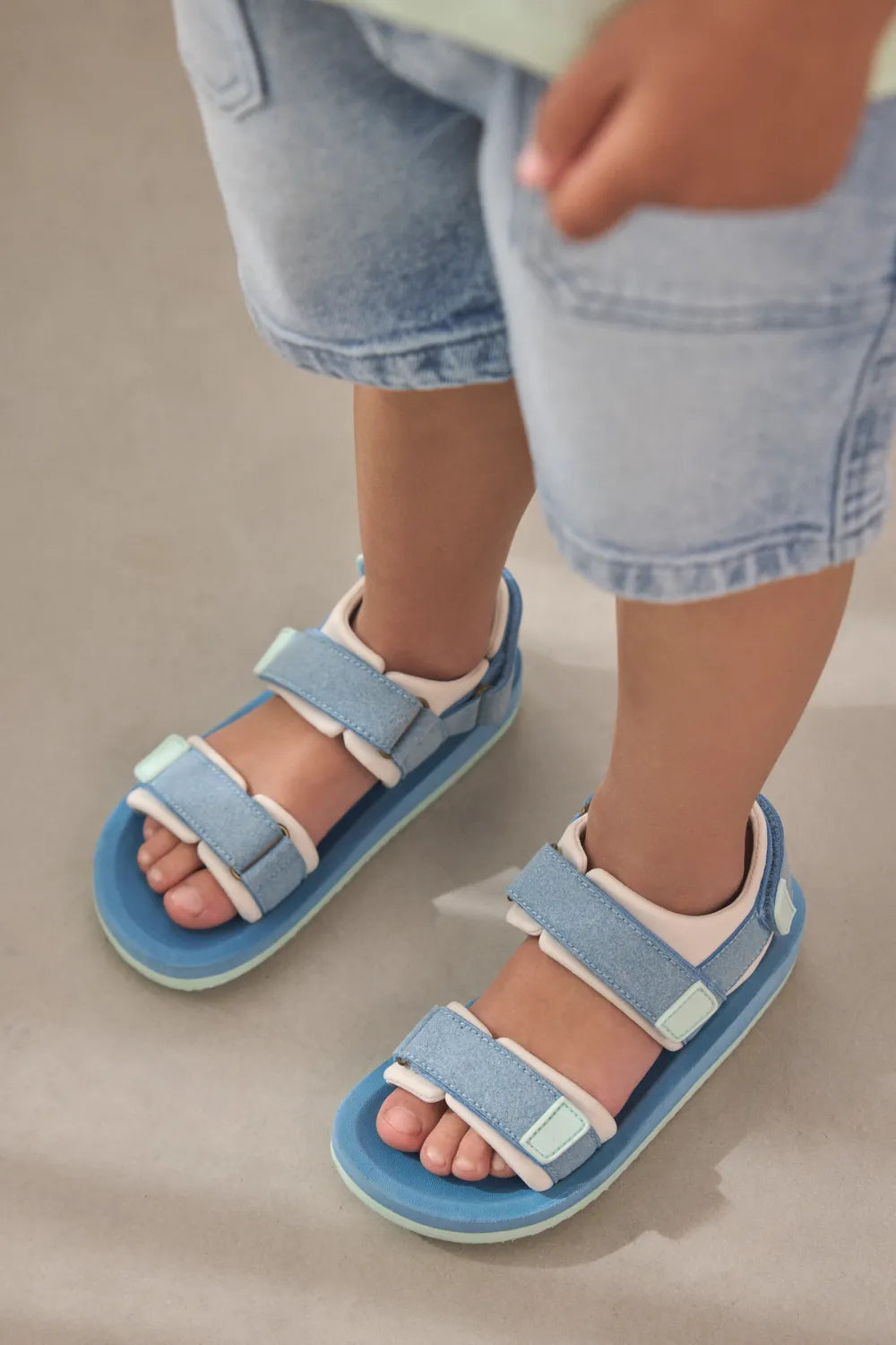 Kindervoeten in blauwe EnFant-sandalen; officiële galerijfoto