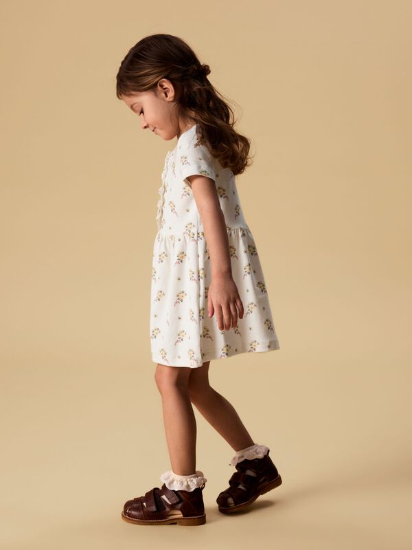 Meisje in een gebloemde Lil’ Atelier-jurk uit de sale