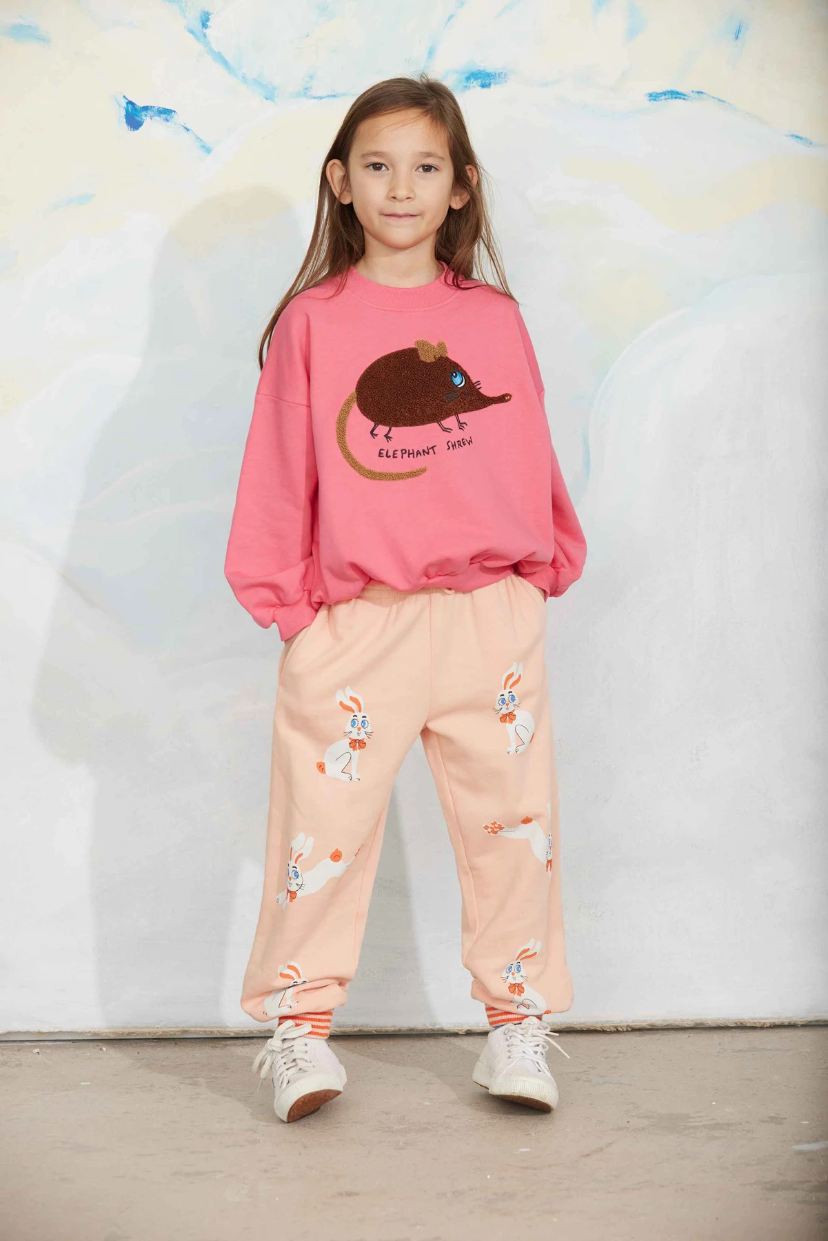 Kind in een roze Mini Rodini-trui met Elephant Shrew-print