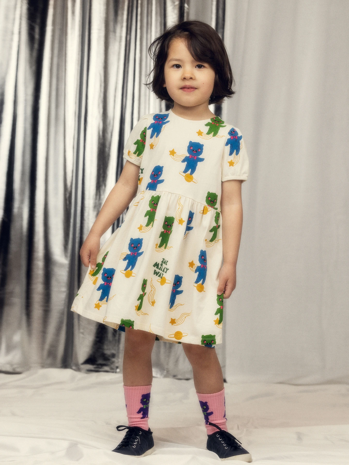 Kind in een Mini Rodini-jurk met ruimteprint