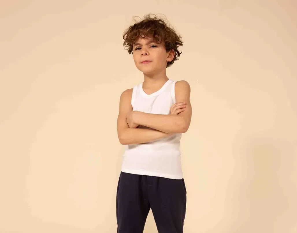 Jongen in een wit Petit Bateau-onderhemd met donkerblauwe broek