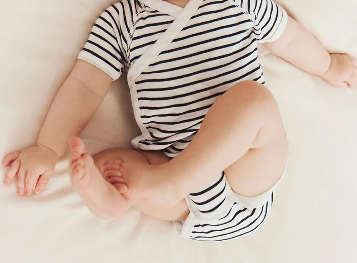 Gedragen detail van een gestreepte Petit Bateau-romper
