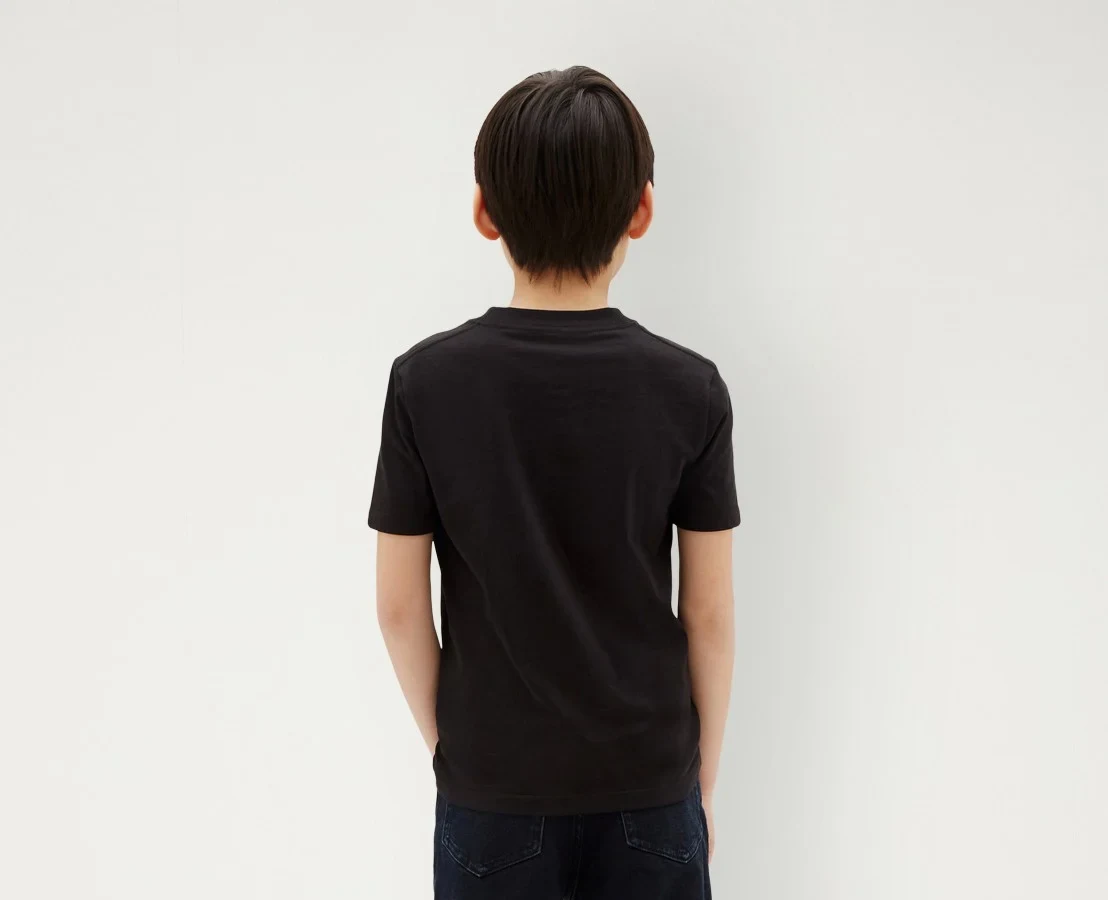 Achteraanzicht van een jongen in een zwart Calvin Klein-T-shirt