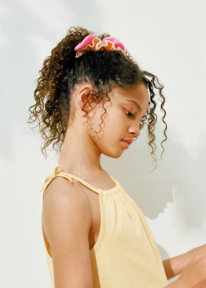 Meisje met een roze Mango-scrunchie in het haar