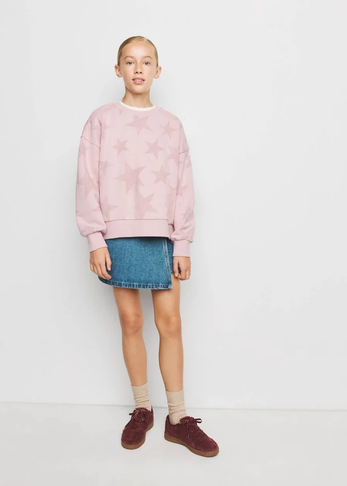 Meisje met een roze Mango-sweatshirt met sterren