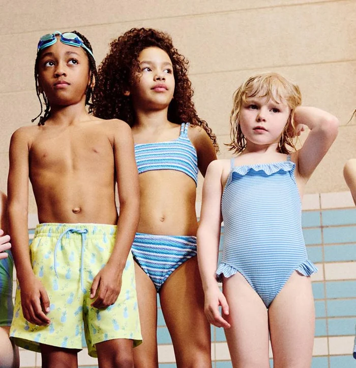 Kinderen in Mango-badmode bij een zwembad