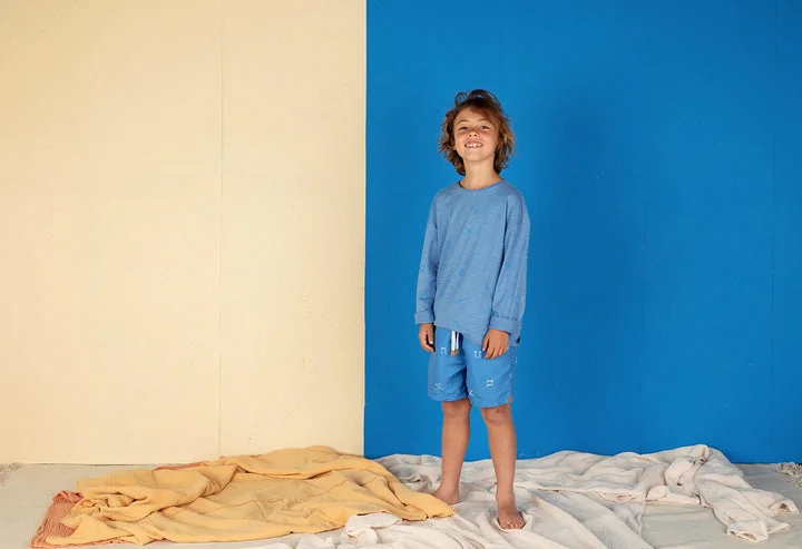 Kind met een blauwe Nixnut-zwemshort