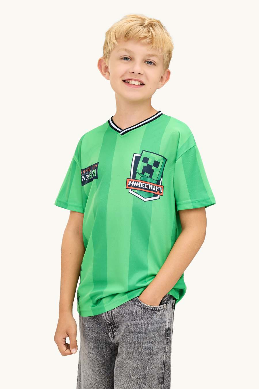 Lachende jongen in een groen Minecraft-shirt uit de sale bij C&A