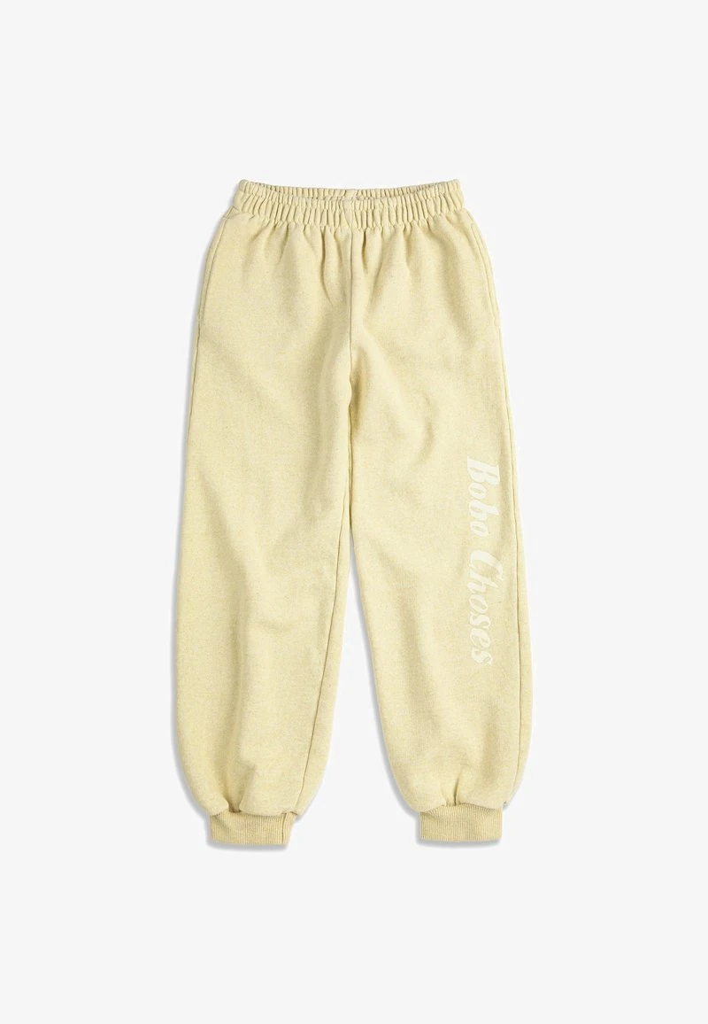 Licht beige fleece joggingbroek met elastische tailleband en boorden, met "Bobo Choses" verticaal gedrukt op het rechterbeen.