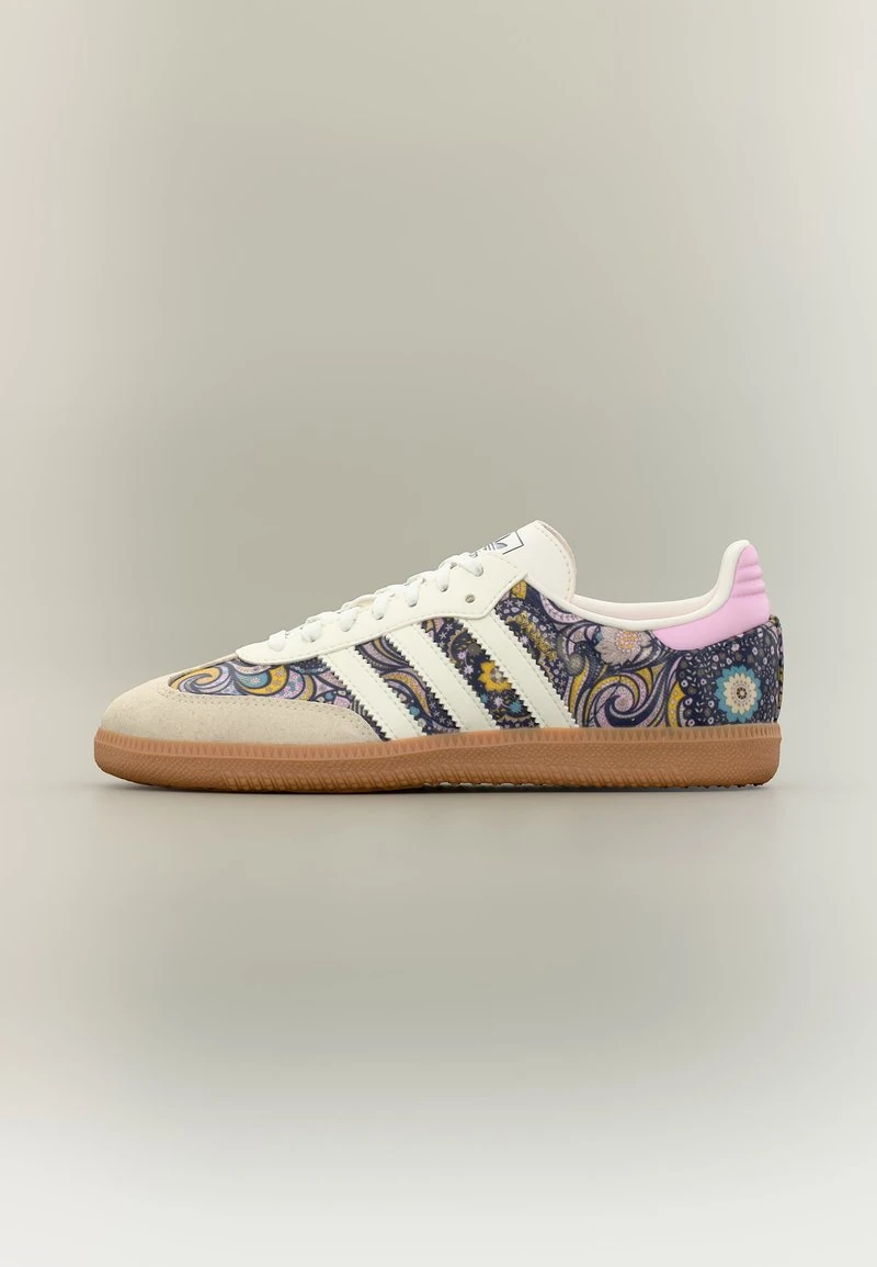 Low-top sneaker met gumzool, witte strepen en paars paisley bloemenpatroon met roze hielaccent, zijaanzicht.